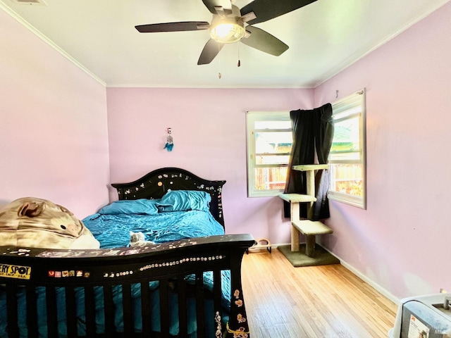 bedroom featuring baseboards, ceiling fan, wood finished floors, and crown molding