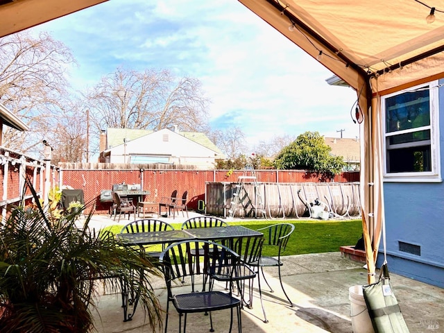 view of patio with a fenced backyard, a pool, and outdoor dining area