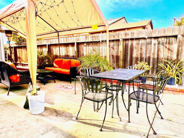 view of patio / terrace with fence, an outdoor living space, and outdoor dining space