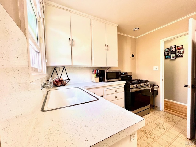 kitchen featuring white cabinetry, appliances with stainless steel finishes, light countertops, and a sink