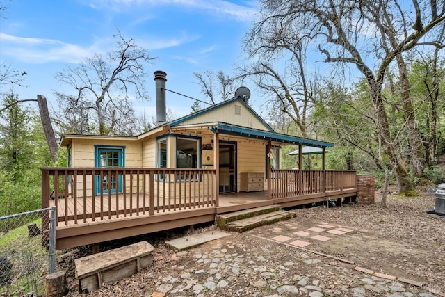 back of house with fence and a deck