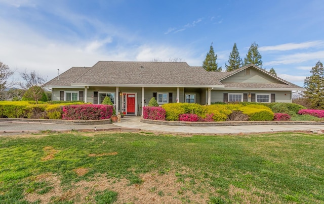 ranch-style home featuring a front lawn and roof with shingles