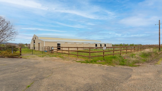 view of yard featuring an outbuilding, an exterior structure, and a rural view