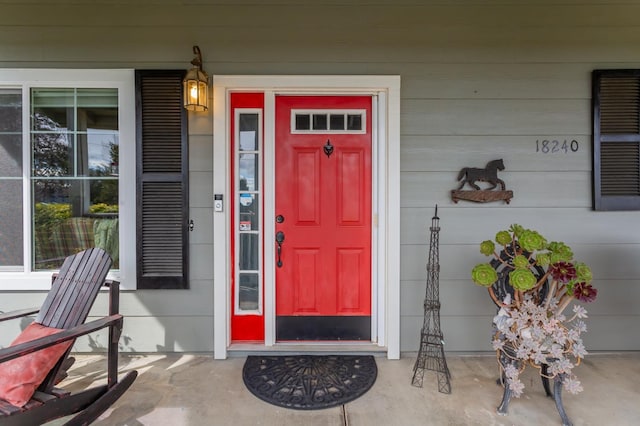 view of exterior entry featuring covered porch