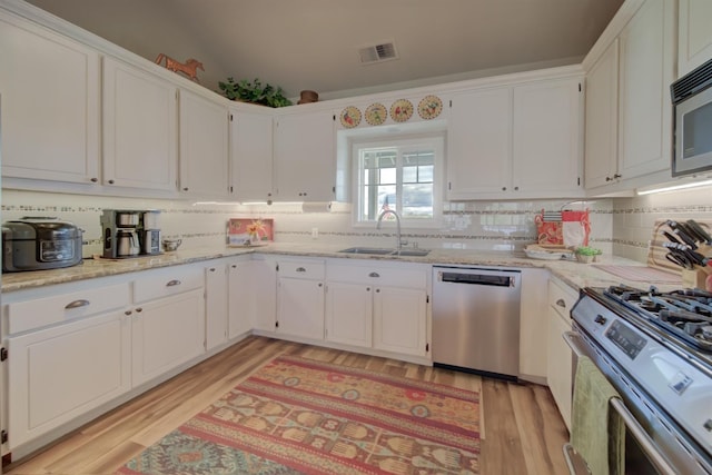 kitchen with white cabinetry, visible vents, a sink, and stainless steel appliances