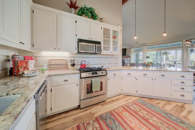 kitchen featuring white cabinets, a peninsula, and stainless steel appliances