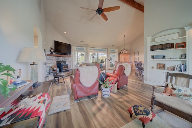 living area with high vaulted ceiling, wood finished floors, and a ceiling fan