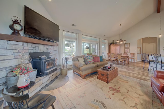 living room with visible vents, high vaulted ceiling, wood finished floors, and an inviting chandelier