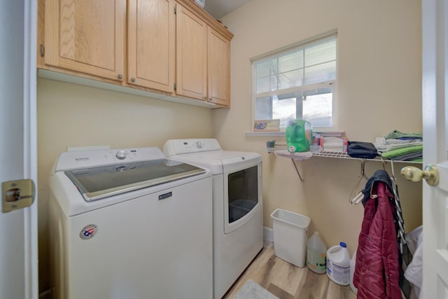 washroom with cabinet space, light wood-style floors, and washer and dryer