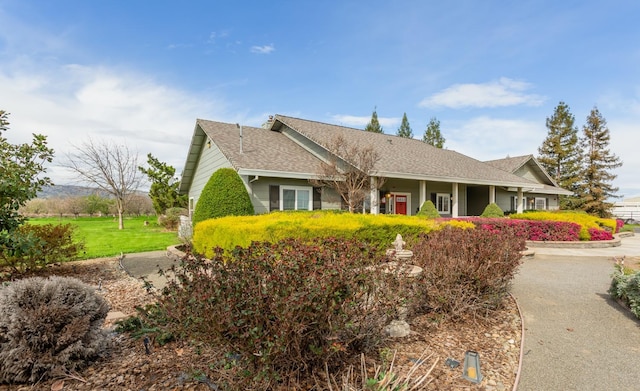 view of front of home featuring a front lawn and roof with shingles