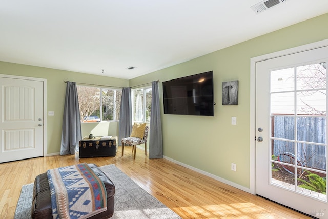 interior space with baseboards, visible vents, and wood finished floors