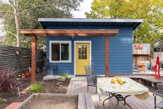 view of outbuilding with an outbuilding, outdoor dining space, and a fenced backyard