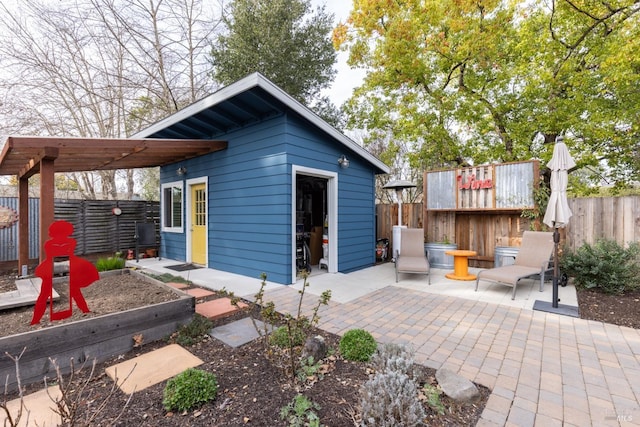 view of outdoor structure featuring a garden, a fenced backyard, and an outdoor structure