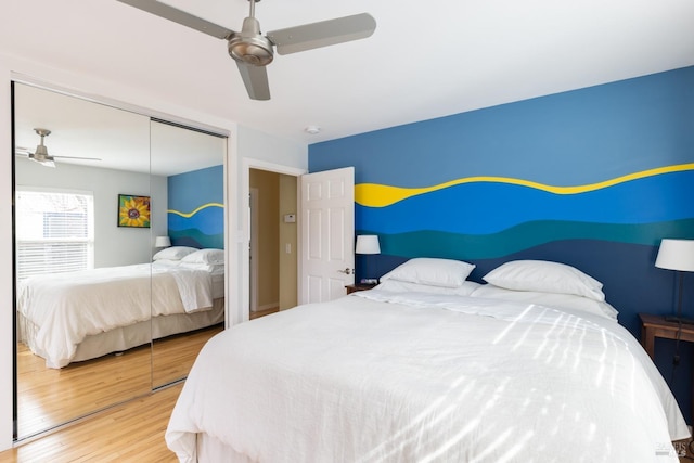 bedroom with a ceiling fan, a closet, and wood finished floors