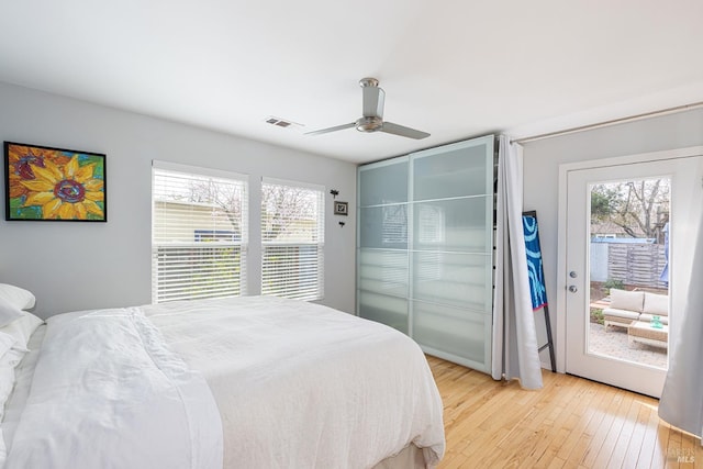 bedroom with light wood-style floors, ceiling fan, multiple windows, and visible vents