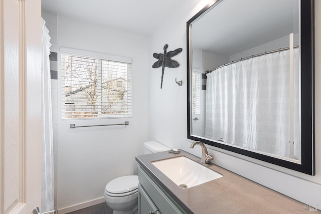 full bath with baseboards, vanity, and toilet