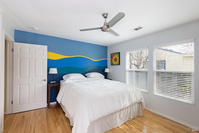 bedroom with visible vents, ceiling fan, baseboards, and wood finished floors