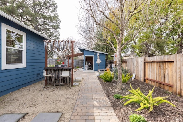 view of patio / terrace featuring a fenced backyard, outdoor dry bar, and an outdoor structure