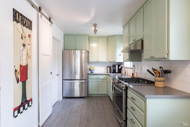 kitchen with stainless steel appliances, backsplash, green cabinetry, and under cabinet range hood