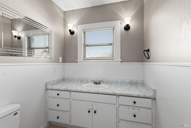 half bath featuring toilet and vanity
