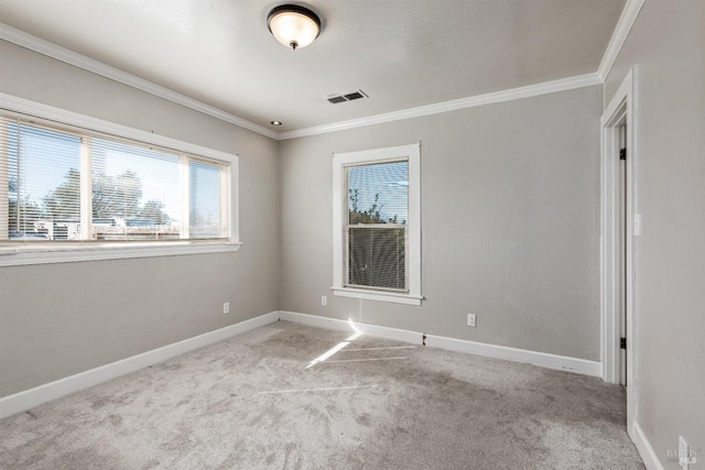 empty room with carpet, visible vents, baseboards, and ornamental molding