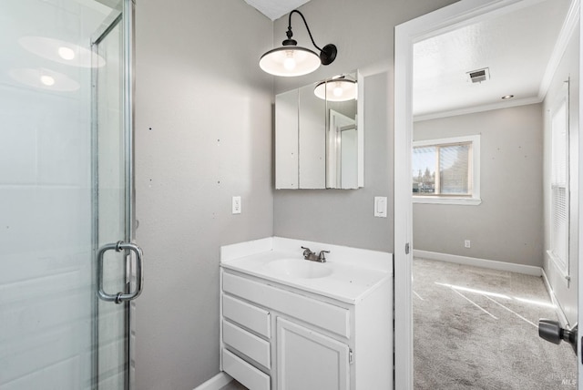 bathroom with vanity, baseboards, visible vents, a stall shower, and crown molding