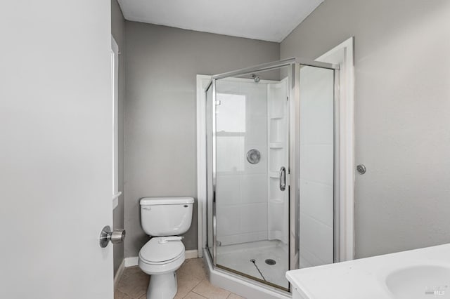 full bath featuring toilet, a stall shower, a sink, and tile patterned floors