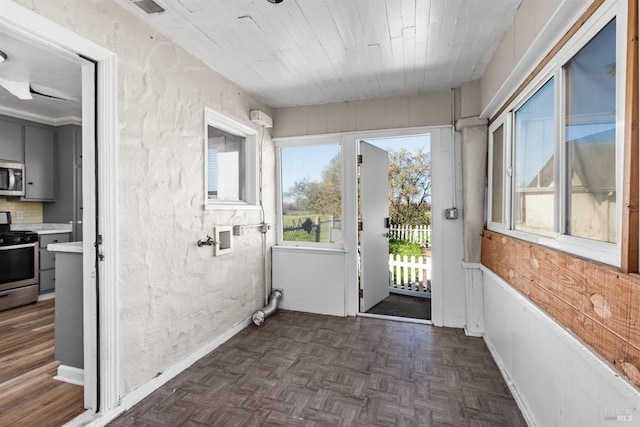 doorway featuring parquet floors, a textured wall, and visible vents