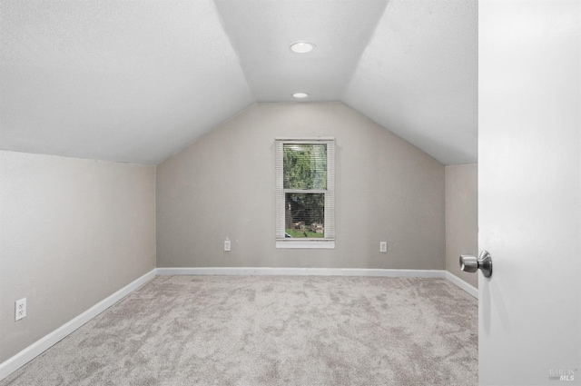 bonus room with carpet, vaulted ceiling, and baseboards