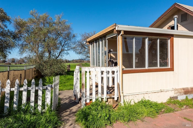 view of property exterior featuring a sunroom and fence