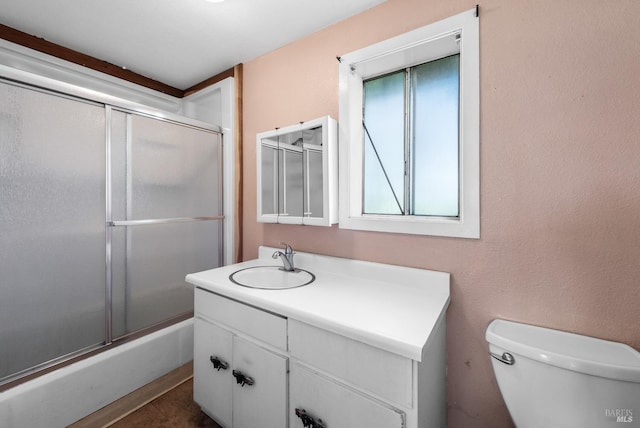 full bathroom with toilet, vanity, and enclosed tub / shower combo