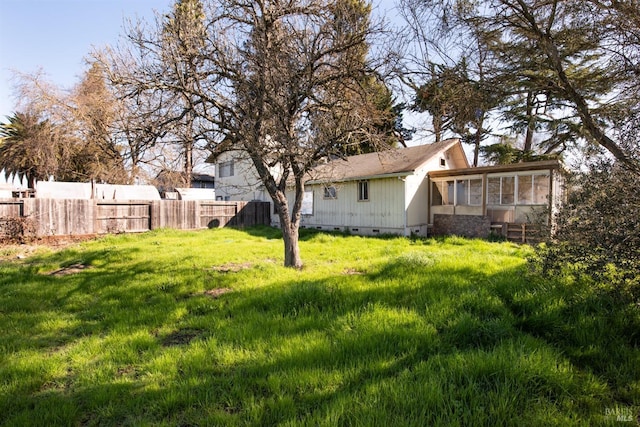 view of yard with a sunroom and fence