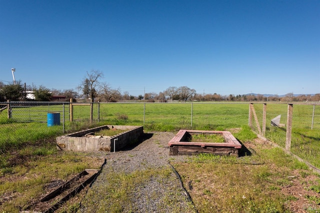 view of yard featuring a garden, fence, and a rural view