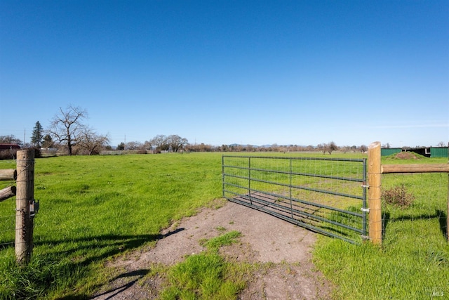 view of gate featuring a rural view and a yard