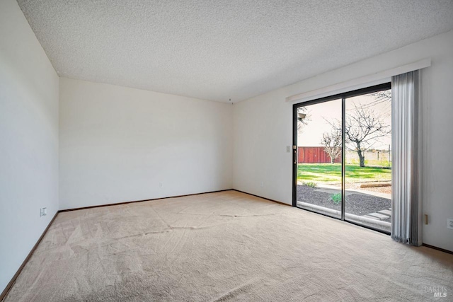 unfurnished room with carpet flooring, a textured ceiling, and baseboards