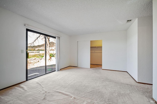 interior space featuring visible vents, a textured ceiling, and baseboards