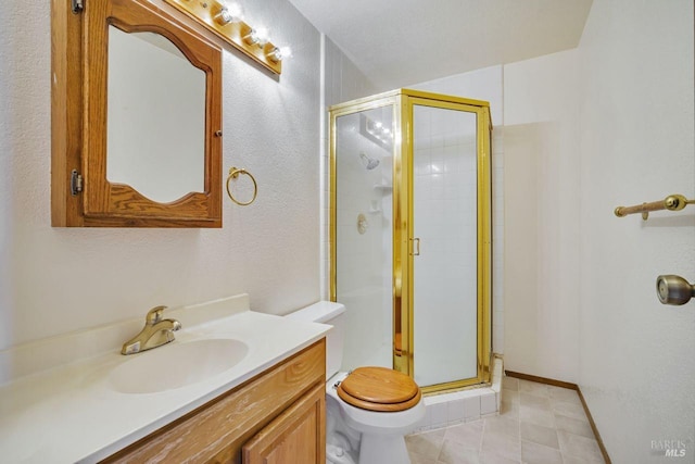 full bathroom featuring a stall shower, baseboards, vanity, and toilet