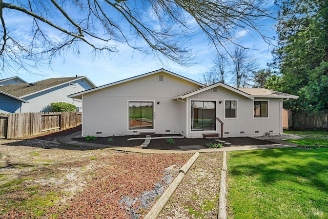 rear view of house featuring crawl space, fence, and a lawn