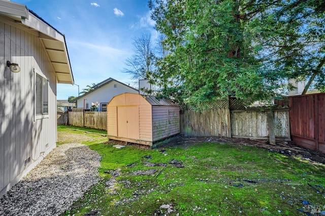 view of yard featuring a shed, an outdoor structure, and a fenced backyard