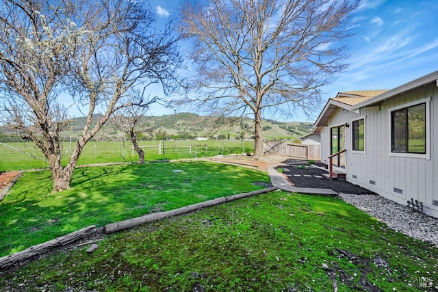 view of yard with a fenced backyard and a mountain view