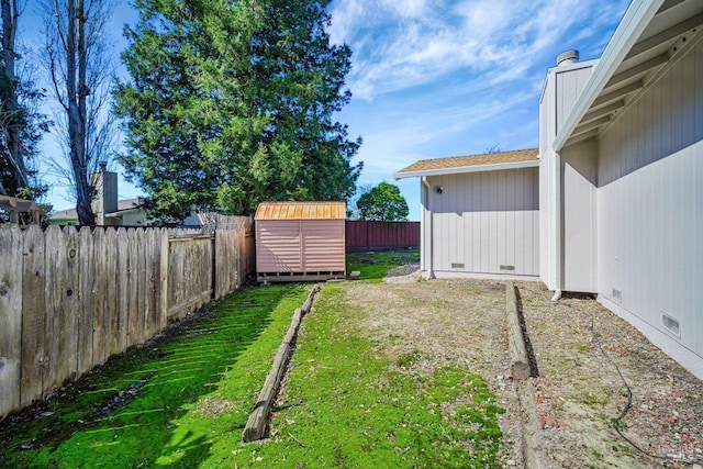 view of yard featuring a fenced backyard, an outdoor structure, and a storage unit