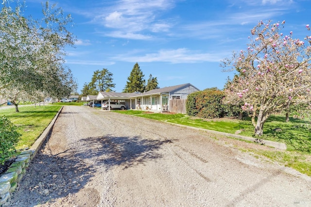 exterior space with driveway, fence, and a front yard