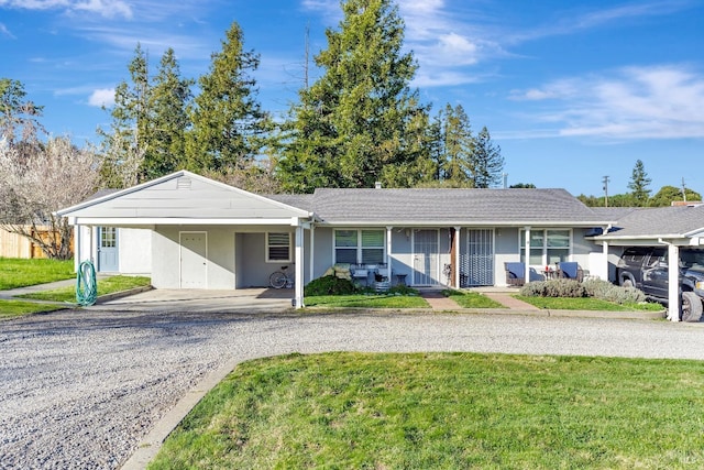 single story home with covered porch, a front lawn, an attached carport, and stucco siding