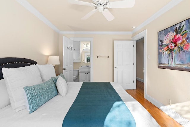 bedroom with baseboards, a ceiling fan, ensuite bath, ornamental molding, and wood finished floors