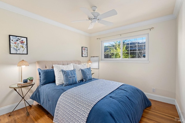 bedroom featuring crown molding, baseboards, ceiling fan, and wood finished floors