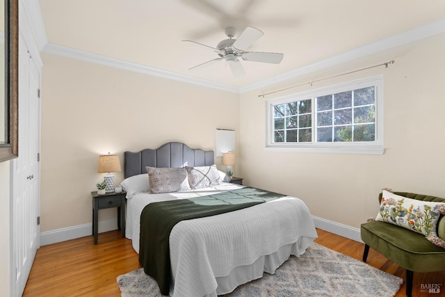 bedroom featuring ornamental molding, light wood finished floors, a ceiling fan, and baseboards