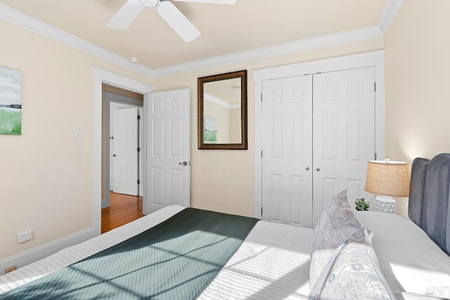 bedroom featuring a ceiling fan, baseboards, ornamental molding, and a closet