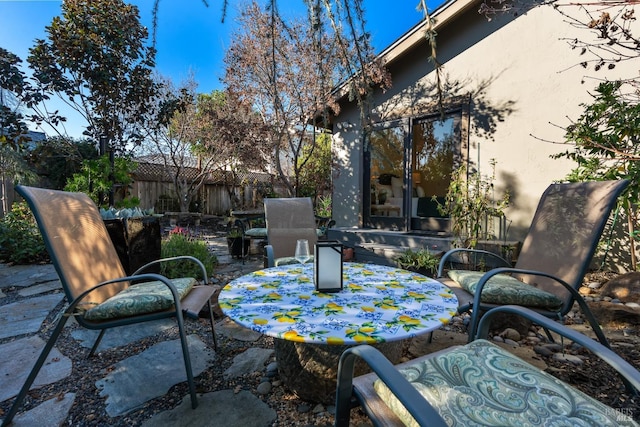 view of patio with outdoor dining space and fence