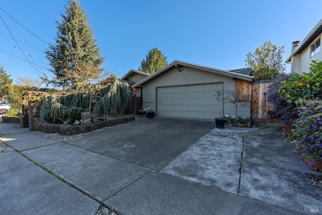 view of front of property featuring an attached garage, concrete driveway, and stucco siding