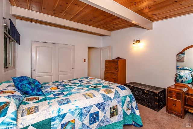 bedroom with a closet, carpet, beam ceiling, and wooden ceiling